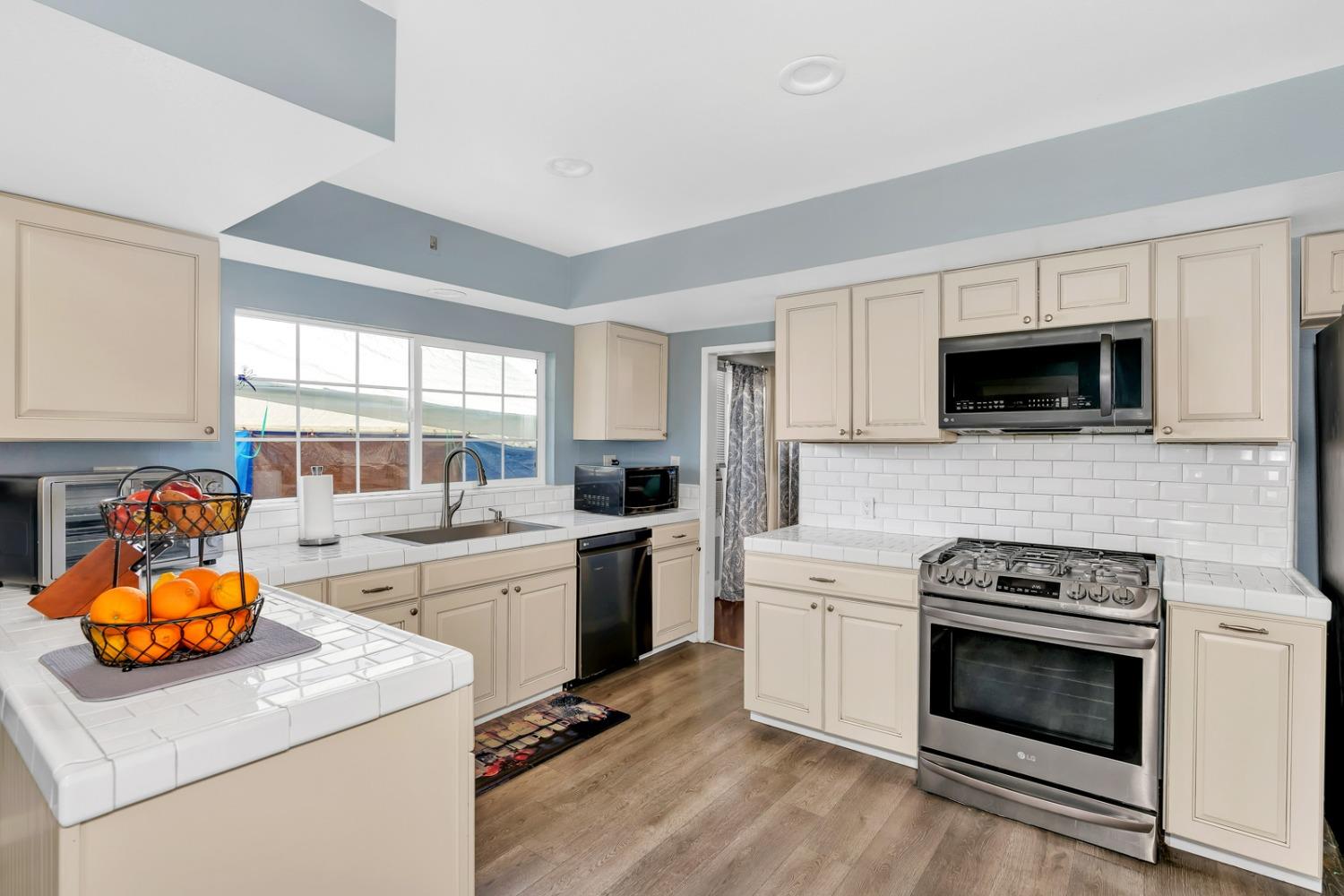 1164 J Street Reedley, CA 93654 - Photo 28 of 43 a kitchen with a stove a sink and a microwave