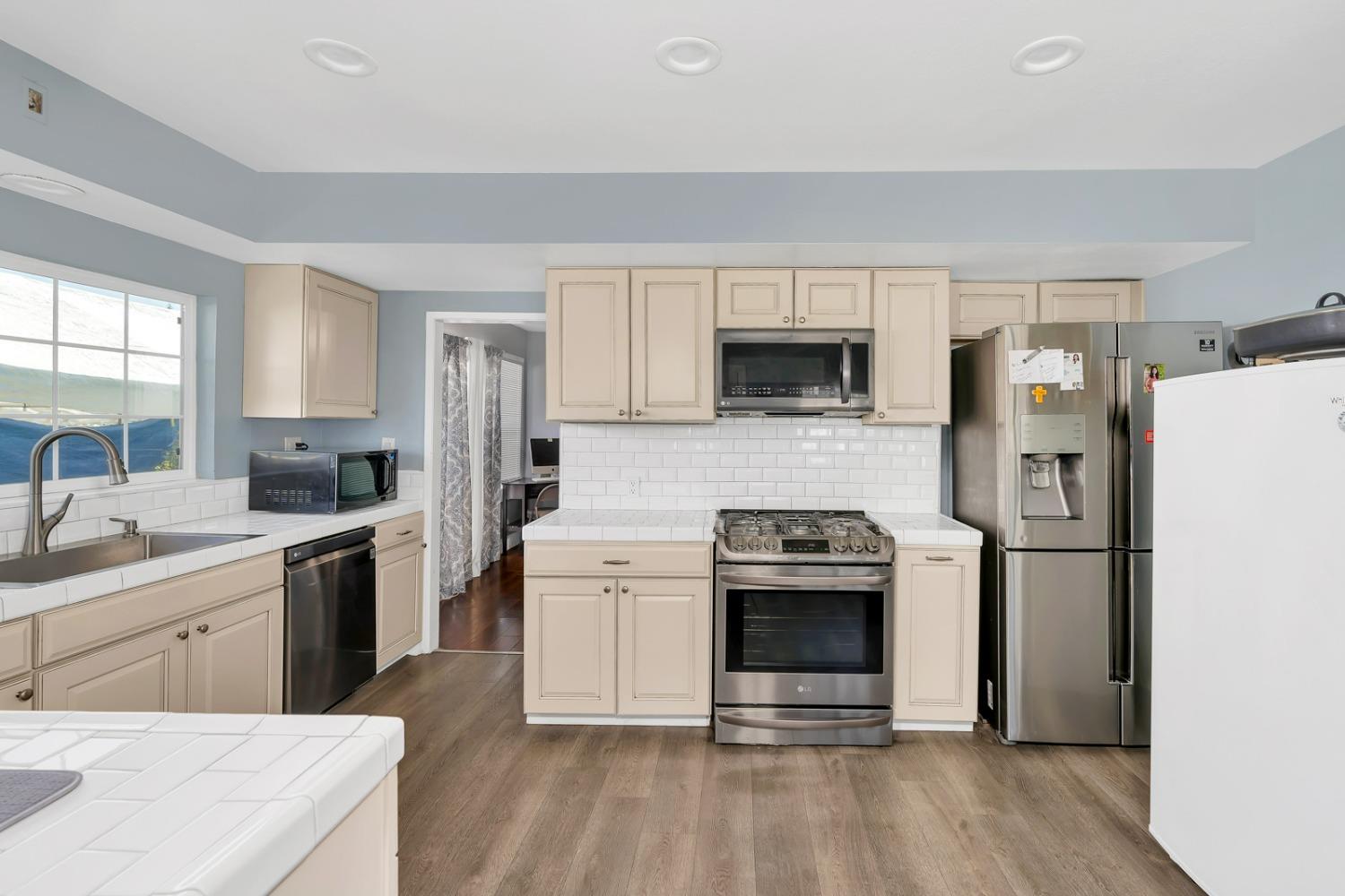 1164 J Street Reedley, CA 93654 - Photo 29 of 43 a kitchen with a stove a refrigerator and a sink