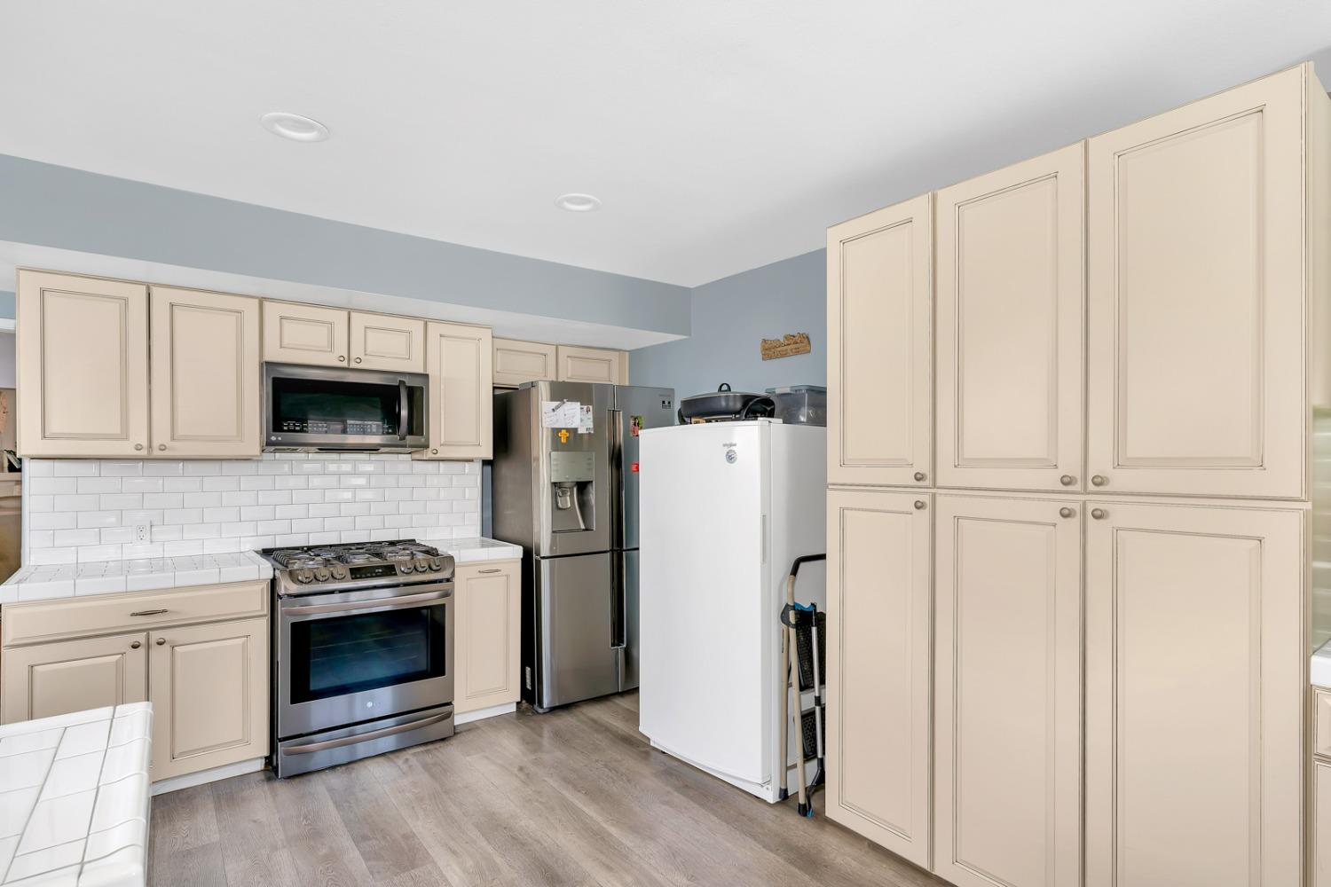 1164 J Street Reedley, CA 93654 - Photo 30 of 43 a kitchen with a refrigerator sink and microwave