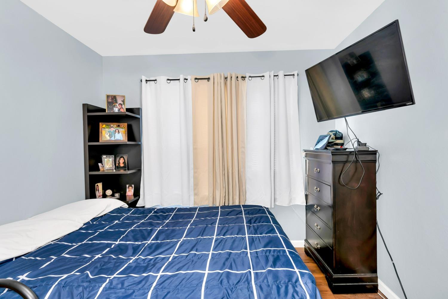 1164 J Street Reedley, CA 93654 - Photo 32 of 43 a bedroom with a bed and a flat tv screen