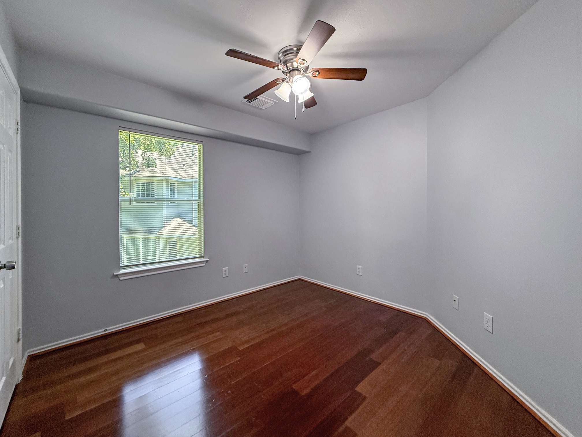 3 Peach Ridge Place The Woodlands, TX 77382 - Photo 18 of 22 a view of an empty room with wooden floor and a window