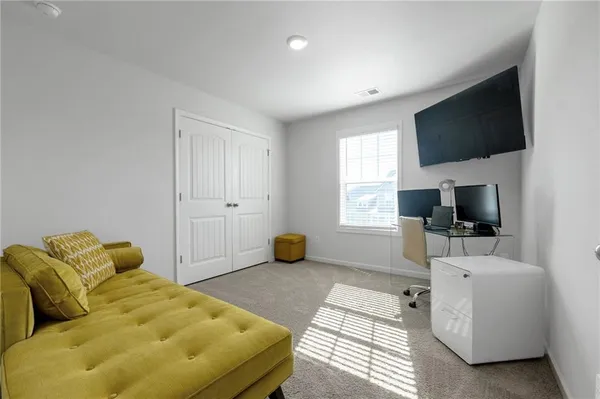 a bedroom with a bed a flat screen tv and a couch