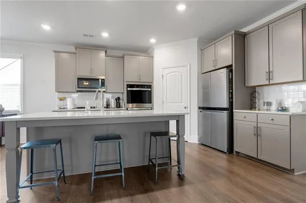 a kitchen with kitchen island white cabinets and stainless steel appliances