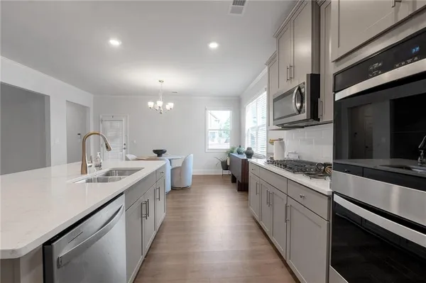 a large kitchen with stainless steel appliances lots of counter space and a sink