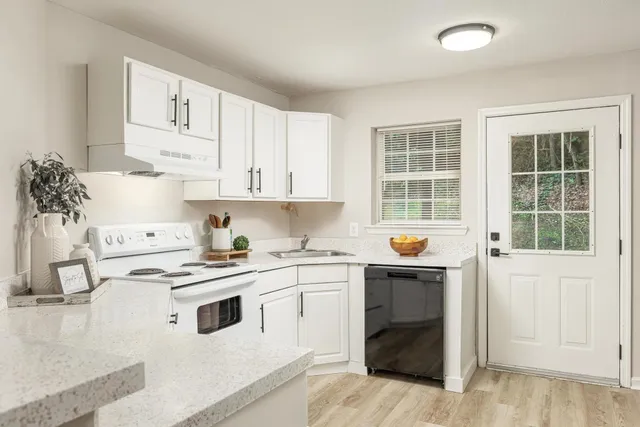 a kitchen with stainless steel appliances white cabinets and wooden floors