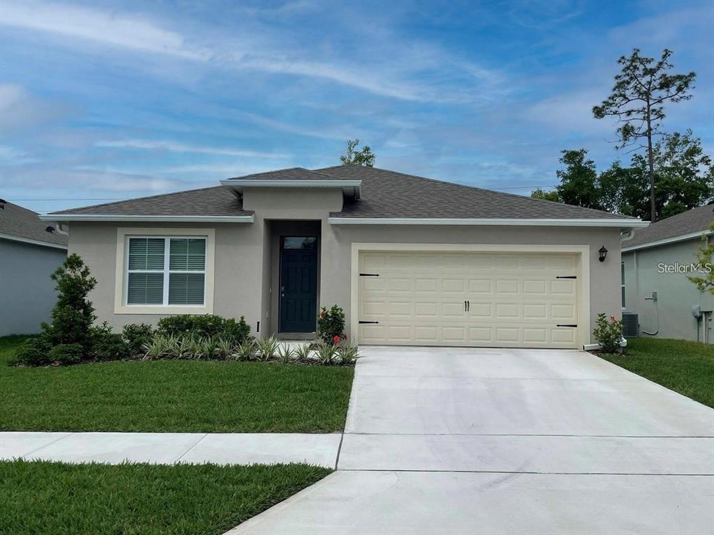 5392 Hickory Downs Way St. Cloud, FL 34771 - Photo 1 of 1 a front view of a house with a yard and garage