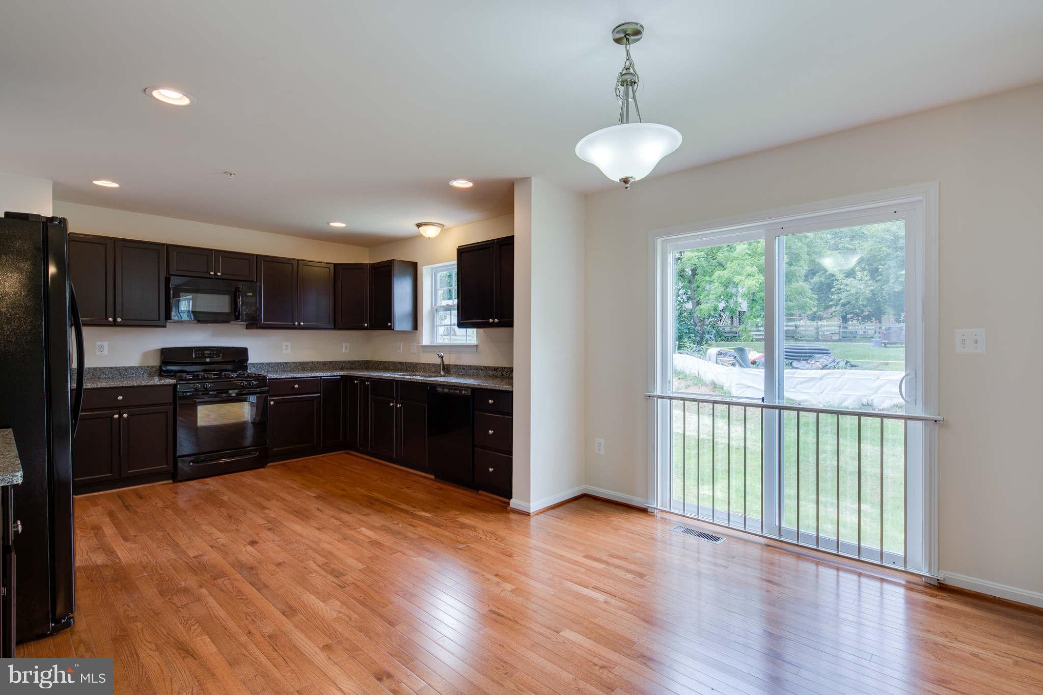 4 Hanover Road Hanover, MD 21076 - Photo 5 of 30 a kitchen with stainless steel appliances granite countertop a refrigerator a sink dishwasher a stove and white countertops with wooden floor