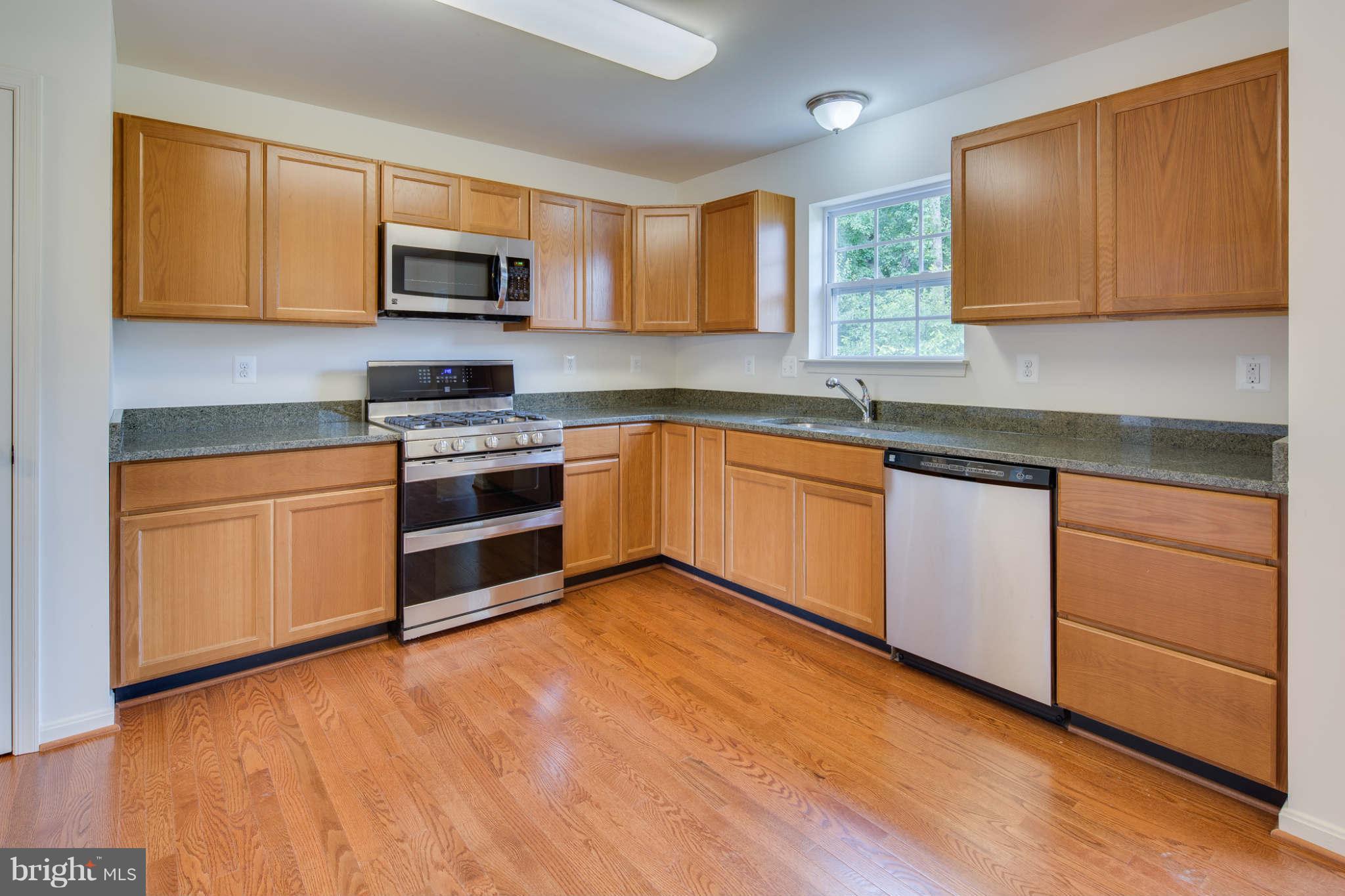 4 Hanover Road Hanover, MD 21076 - Photo 7 of 30 a kitchen with stainless steel appliances granite countertop a stove top oven a sink dishwasher and white cabinets