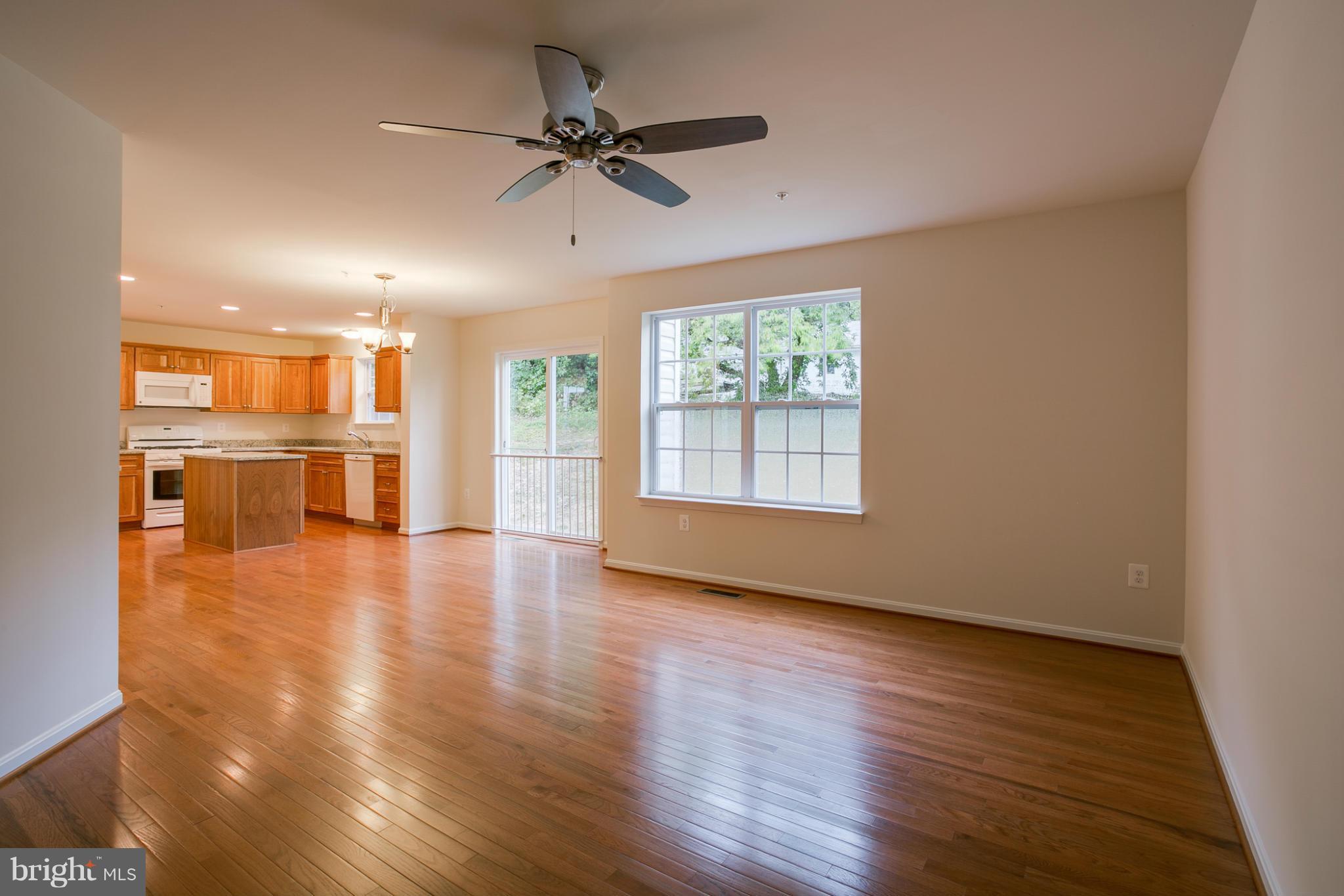 4 Hanover Road Hanover, MD 21076 - Photo 10 of 30 an empty room with wooden floor a ceiling fan and windows