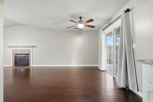 a view of a hallway with wooden floor and a ceiling fan