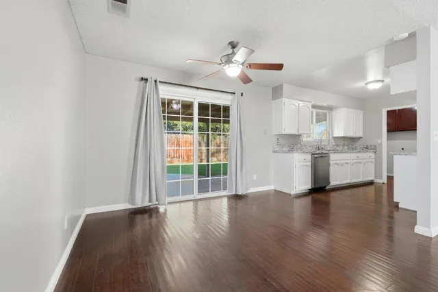 a view of a kitchen with wooden floor and a window