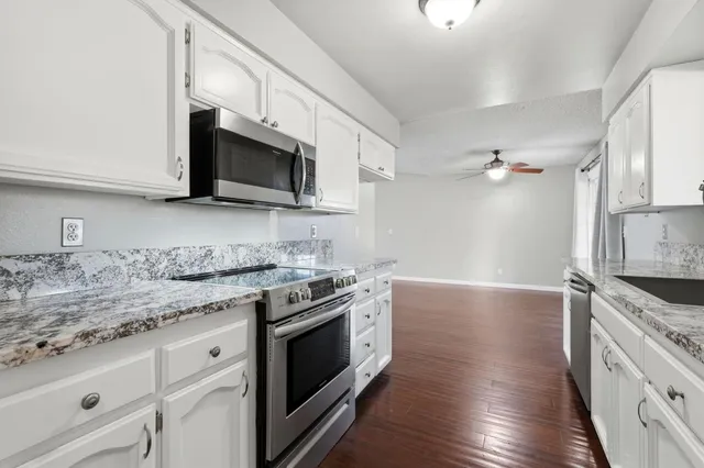 a kitchen with stainless steel appliances granite countertop a stove microwave and sink