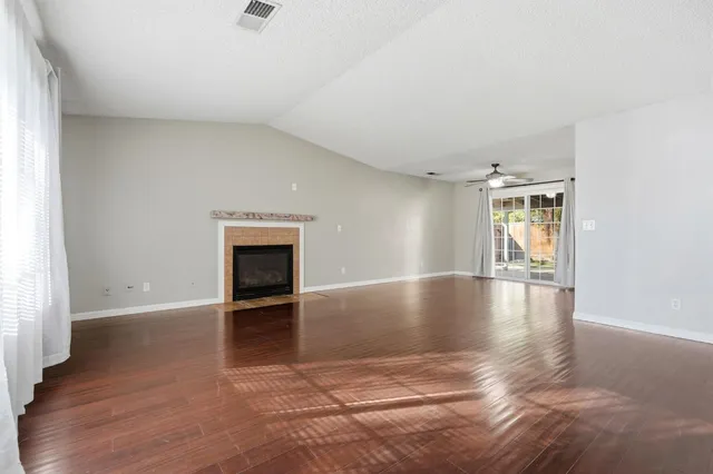 an empty room with wooden floor and fireplace