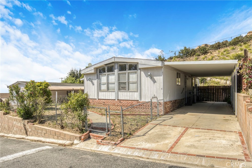 24425 Woolsey Canyon Road, Unit 5 West Hills, CA 91304 - Photo 3 of 17 a front view of a house with a yard