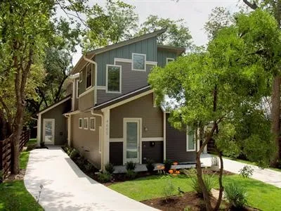 a front view of house with yard and trees in the background