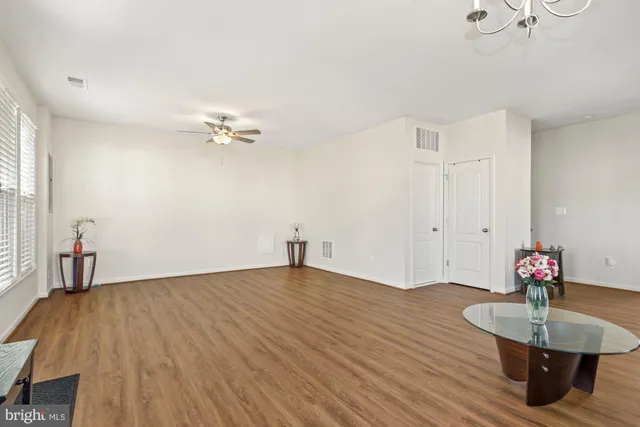 a view of a room with wooden floor and ceiling fan