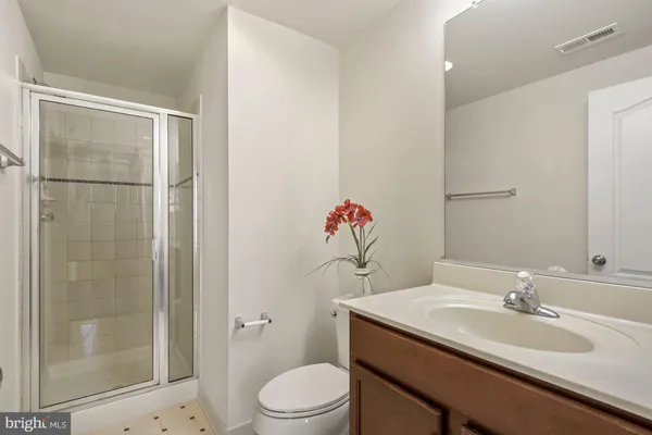 a bathroom with a granite countertop sink toilet a mirror and shower
