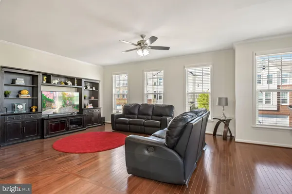 a living room with furniture a flat screen tv and wooden floor