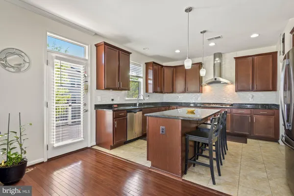 a kitchen with kitchen island granite countertop wooden floors cabinets a sink and a counter