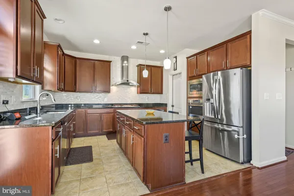 a kitchen with stainless steel appliances granite countertop a refrigerator stove and sink