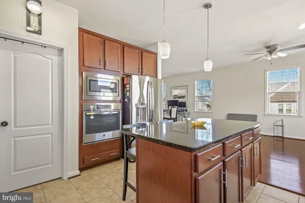a kitchen with stainless steel appliances granite countertop a refrigerator a stove and a sink with granite countertops