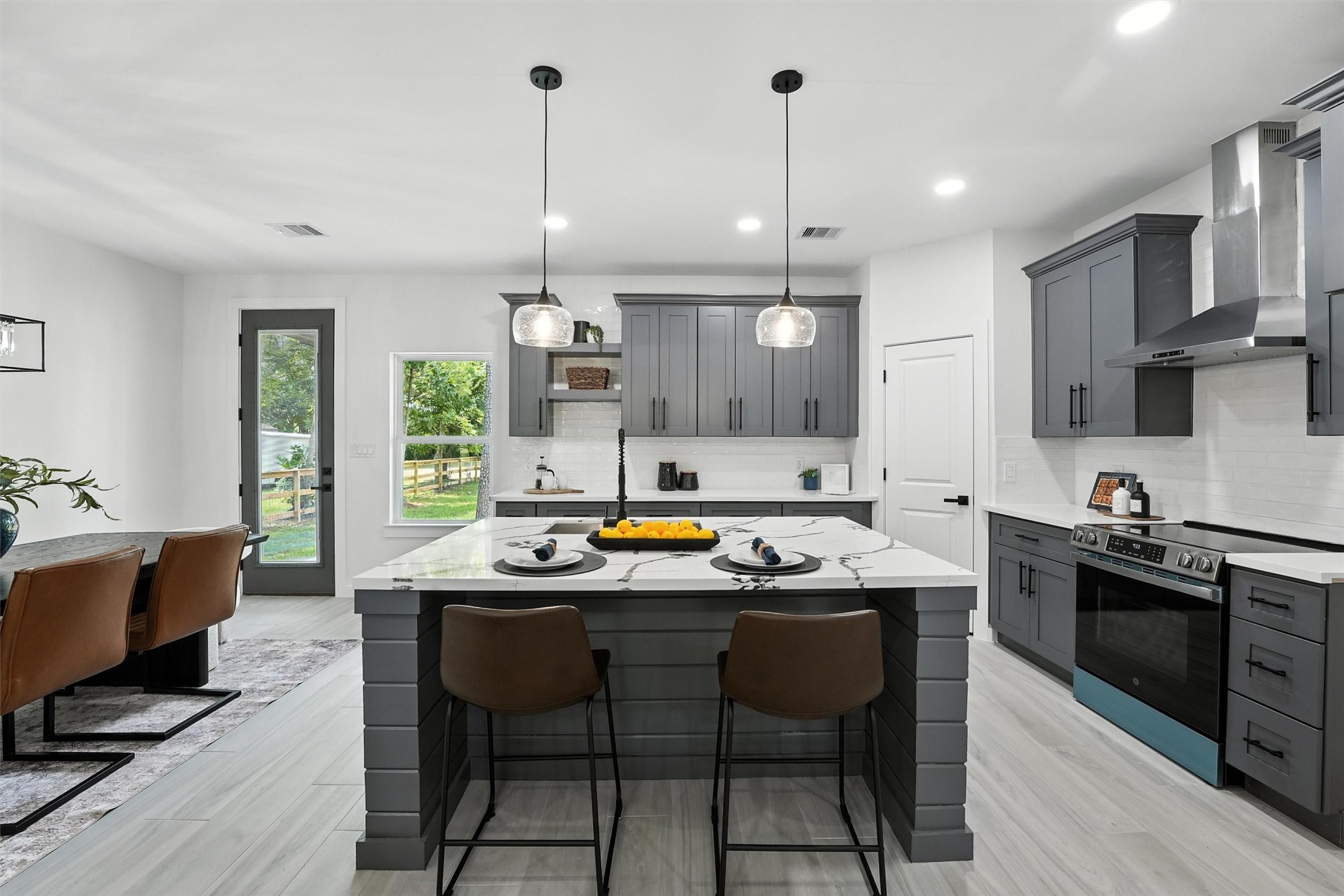 252 Davis Bend Road Alvin, TX 77511 - Photo 11 of 32 a kitchen with stainless steel appliances granite countertop a stove a sink dishwasher a dining table and chairs with wooden floor
