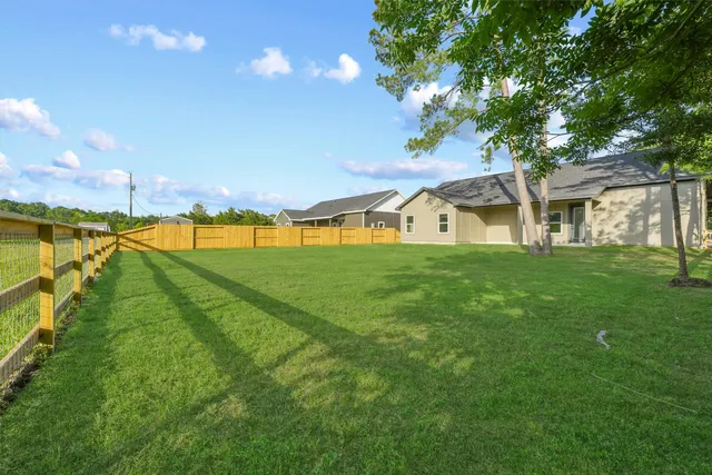 a view of an house with backyard and a tree