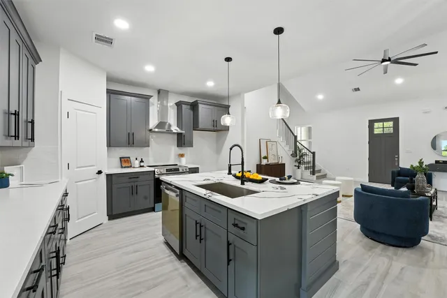 a kitchen with a sink a counter top space and stainless steel appliances