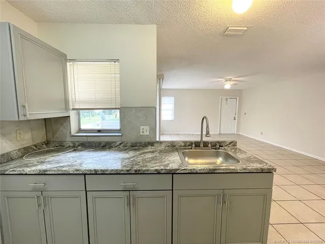 a kitchen with granite countertop a sink and cabinets