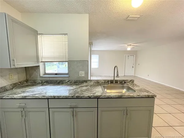 a kitchen with granite countertop a sink and cabinets