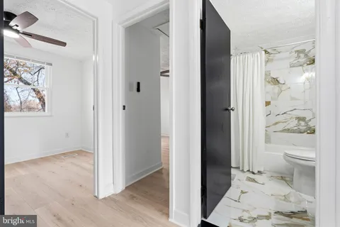 a view of bedroom with wooden floor and bathroom
