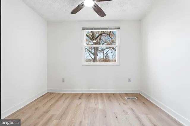 an empty room with a window and wooden floor