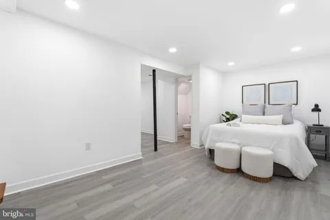 a spacious bedroom with a bed and wooden floor