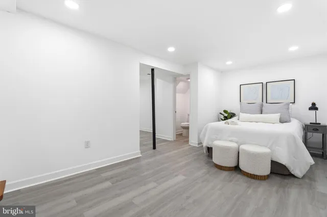 a spacious bedroom with a bed and wooden floor