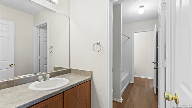 a bathroom with a granite countertop sink and a mirror