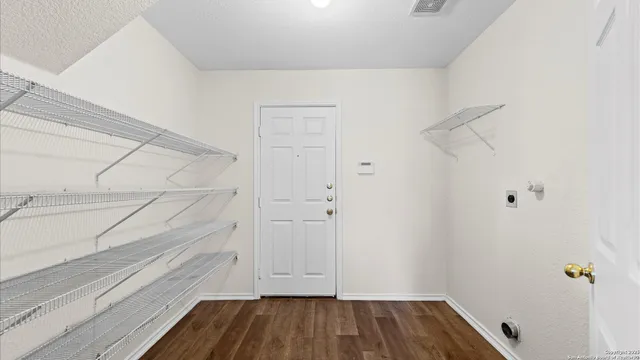 a view of walk in closet with wooden floor