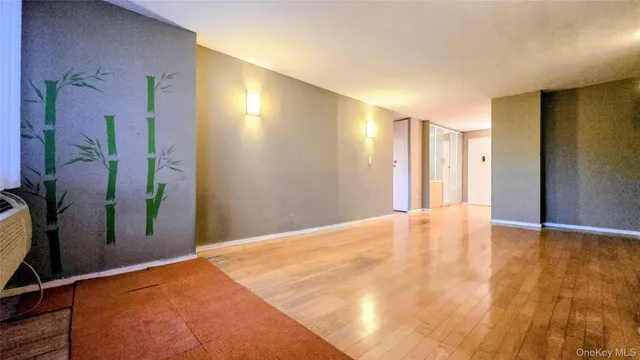 a view of empty room with a fireplace and wooden floor