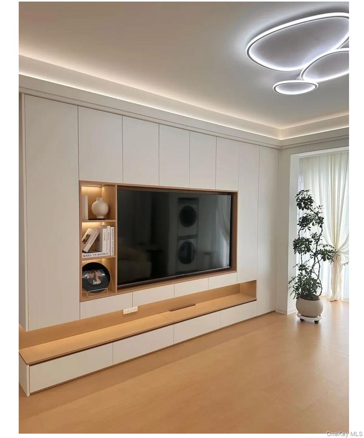 118-18 Union Turnpike, Unit 4B Queens, NY 11415 - Photo 29 of 30 a living room with furniture and a flat screen tv