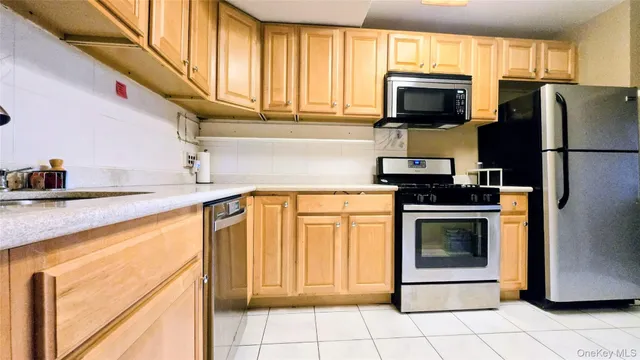 a kitchen with stainless steel appliances granite countertop white cabinets a stove top oven a sink and dishwasher