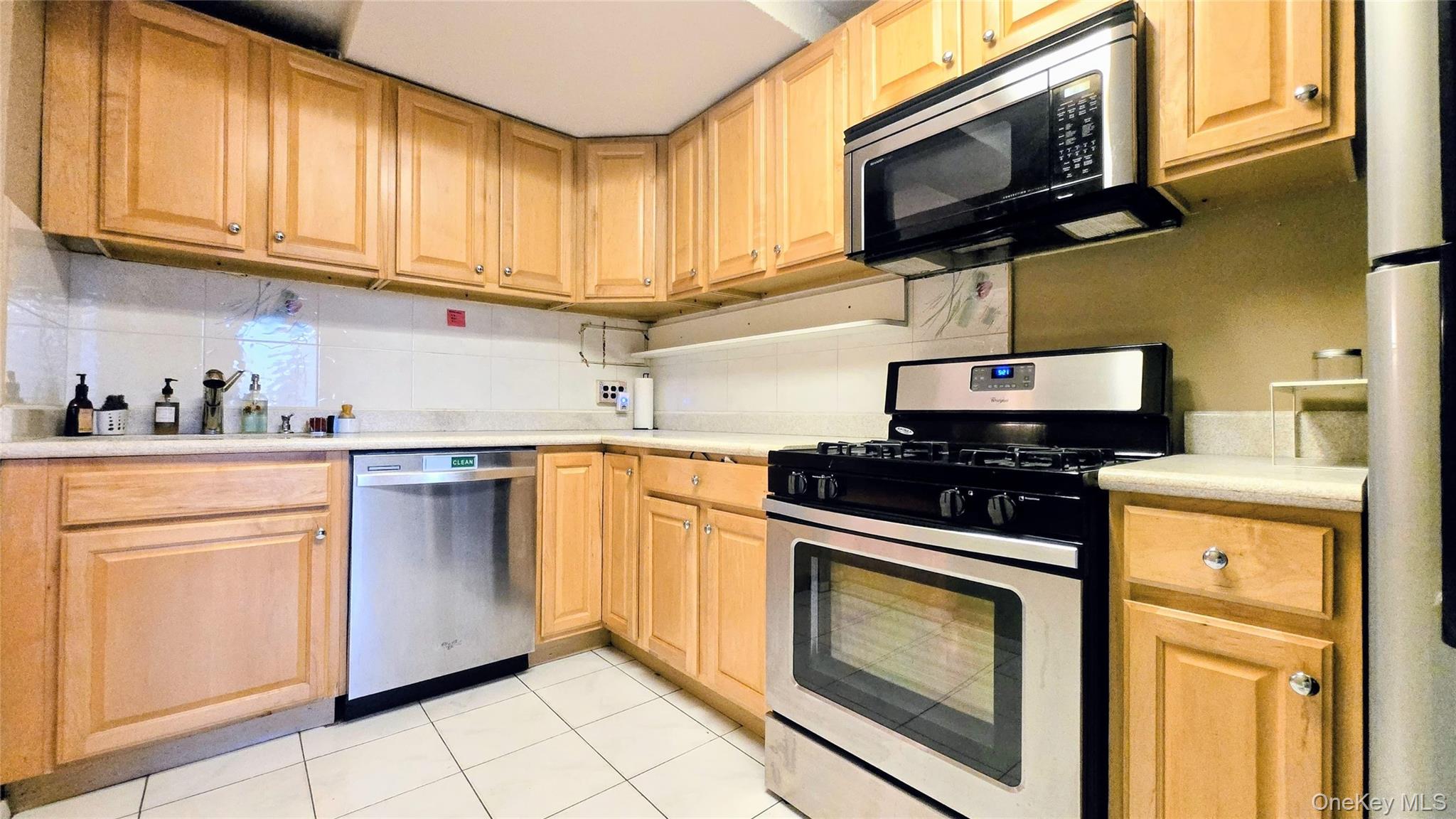 118-18 Union Turnpike, Unit 4B Queens, NY 11415 - Photo 4 of 30 a kitchen with stainless steel appliances granite countertop white cabinets a stove top oven a sink and dishwasher