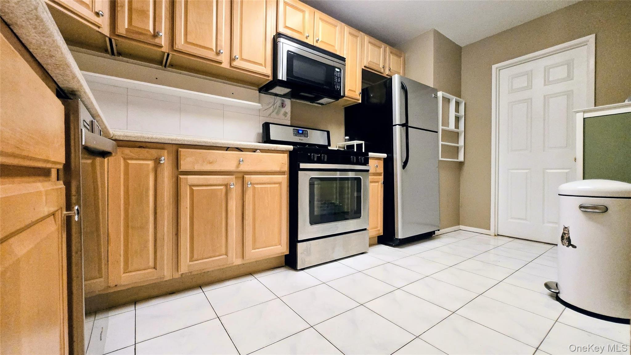 118-18 Union Turnpike, Unit 4B Queens, NY 11415 - Photo 5 of 30 a kitchen with stainless steel appliances granite countertop a refrigerator and a stove top oven