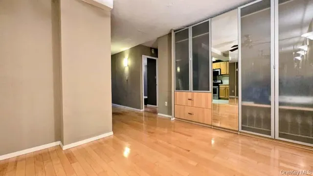a view of empty room with wooden floor and fan