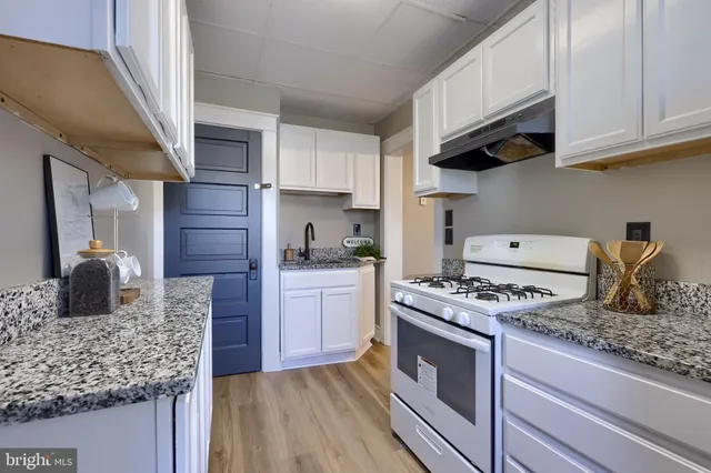 a kitchen with stainless steel appliances granite countertop a stove a sink and a microwave