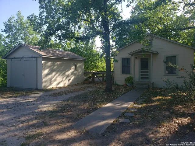 a small barn with a stove and a large tree