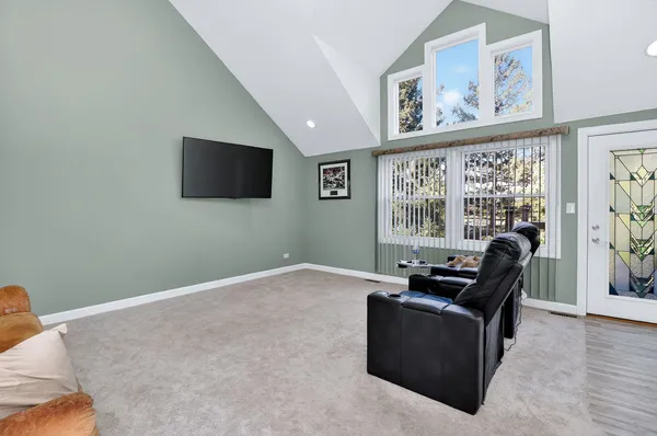 a living room with furniture a flat screen tv and a window