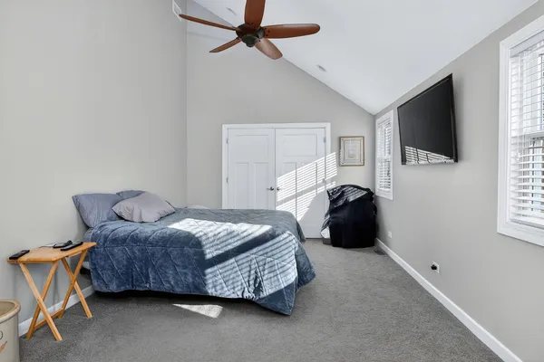 a bedroom with a bed a flat screen tv and window