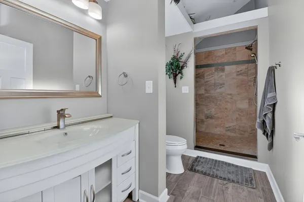 a bathroom with a sink a toilet and shower