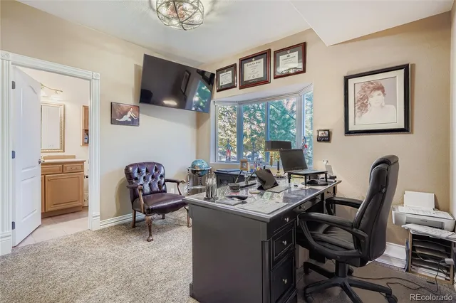 a work room with furniture a flat screen tv and a window