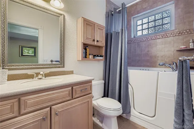 a bathroom with a granite countertop toilet sink and mirror