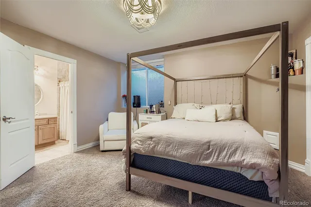 a bedroom with a large bed and a chandelier